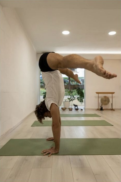 Georgios demonstrating strength, balance and movement awareness in a handstand